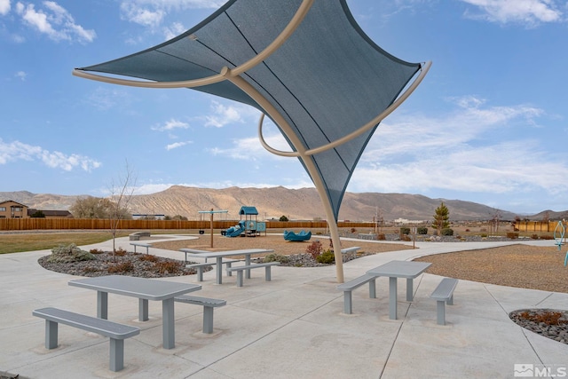 view of patio with a playground and a mountain view