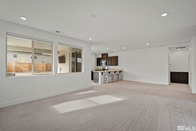 unfurnished living room with light colored carpet