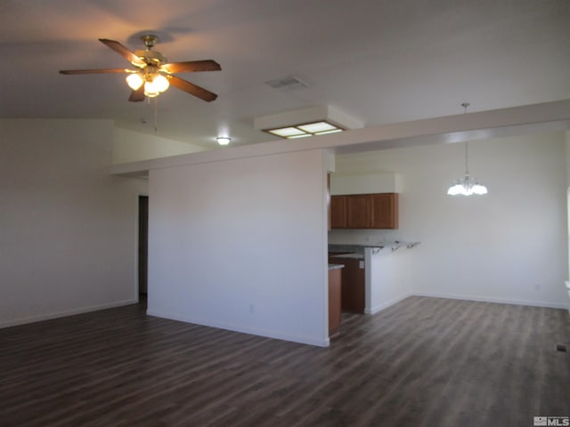 unfurnished living room with ceiling fan with notable chandelier and dark hardwood / wood-style flooring