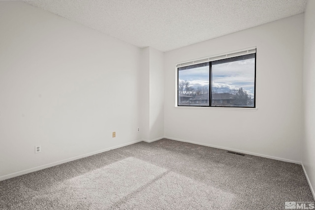 carpeted empty room with a textured ceiling