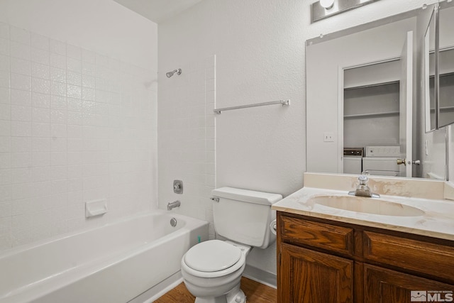 full bathroom with washing machine and clothes dryer, toilet, shower / tub combination, vanity, and hardwood / wood-style flooring