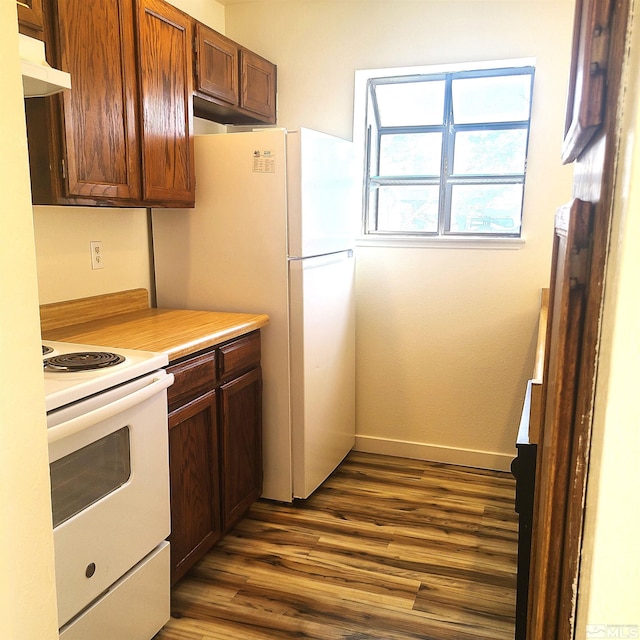 kitchen featuring dark wood-type flooring and white appliances