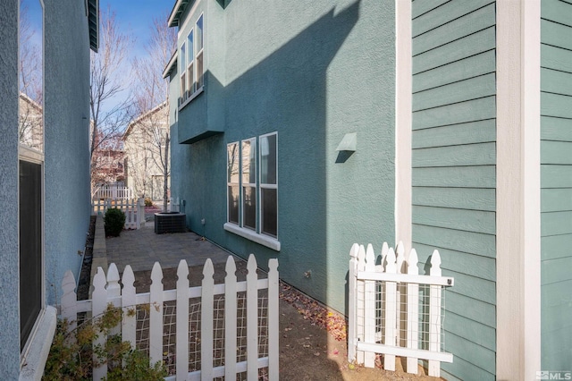 view of side of property featuring central AC and a patio area