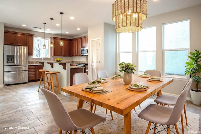 dining room featuring light wood-type flooring and an inviting chandelier