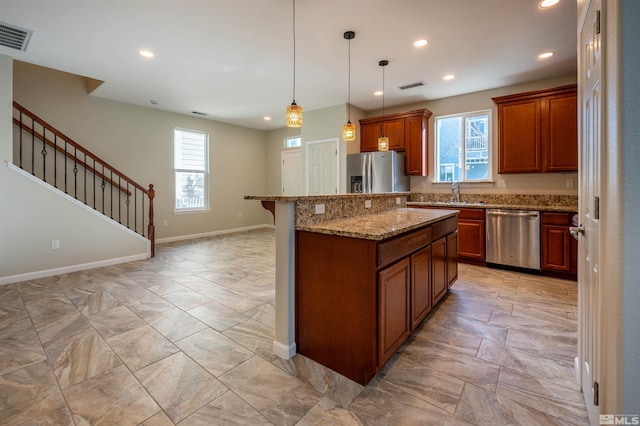 kitchen featuring plenty of natural light, a kitchen island, a breakfast bar area, and stainless steel appliances