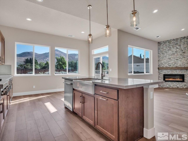 kitchen with a mountain view, stainless steel dishwasher, a wealth of natural light, and hanging light fixtures