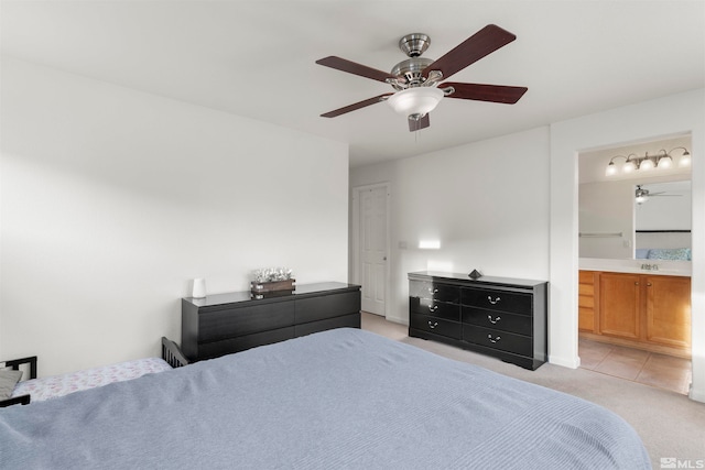 bedroom featuring connected bathroom, ceiling fan, and light carpet