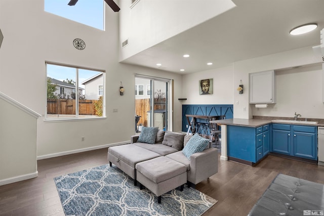 living room featuring sink, ceiling fan, a healthy amount of sunlight, and dark hardwood / wood-style flooring