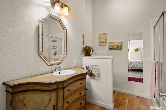 bathroom featuring vanity, a shower with shower door, and hardwood / wood-style flooring