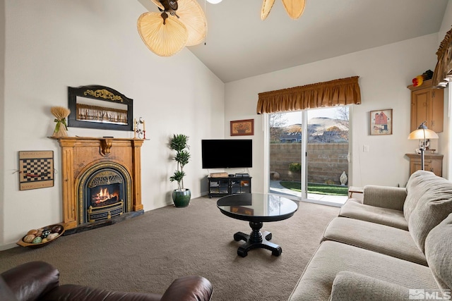 living room with ceiling fan, carpet floors, and lofted ceiling