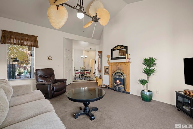 living room featuring ceiling fan with notable chandelier, high vaulted ceiling, and carpet