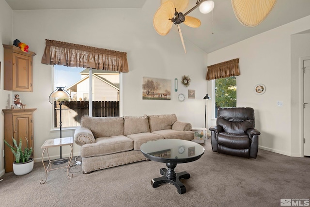 carpeted living room with a wealth of natural light, ceiling fan, and high vaulted ceiling