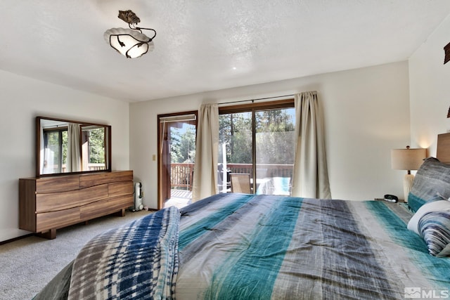 carpeted bedroom featuring access to exterior and a textured ceiling