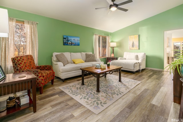 living room with ceiling fan, light hardwood / wood-style flooring, and vaulted ceiling