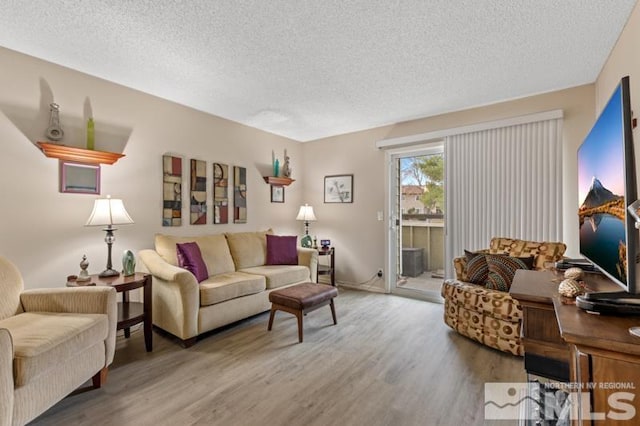 living room with wood-type flooring and a textured ceiling