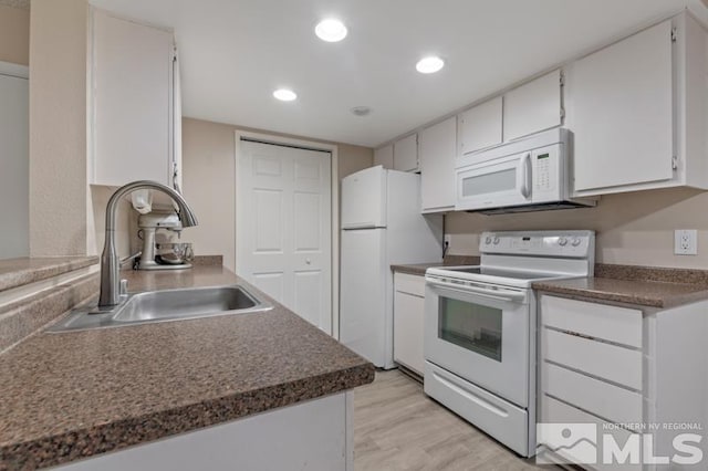 kitchen with white appliances, light hardwood / wood-style floors, white cabinetry, and sink