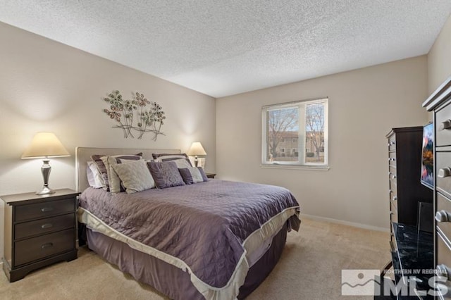 bedroom featuring light carpet and a textured ceiling