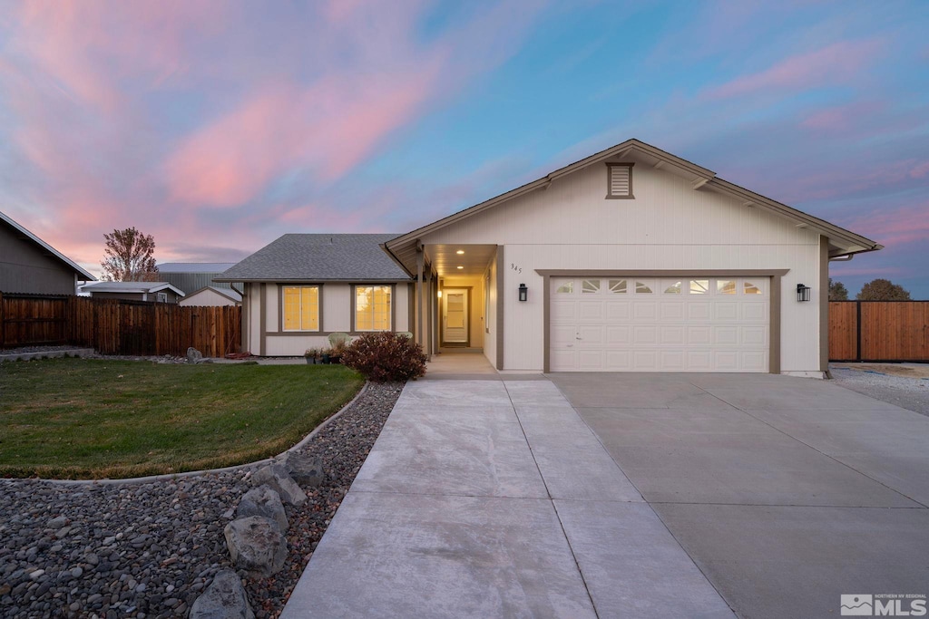 ranch-style home featuring a lawn and a garage