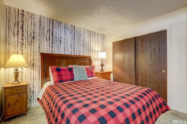 carpeted bedroom with a textured ceiling and a closet