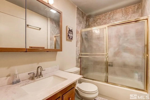 full bathroom featuring vanity, toilet, and combined bath / shower with glass door