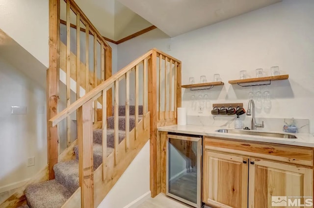 kitchen with light brown cabinetry, sink, and beverage cooler