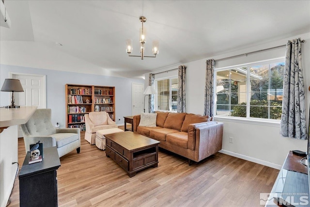 living room featuring a chandelier, light hardwood / wood-style floors, and vaulted ceiling