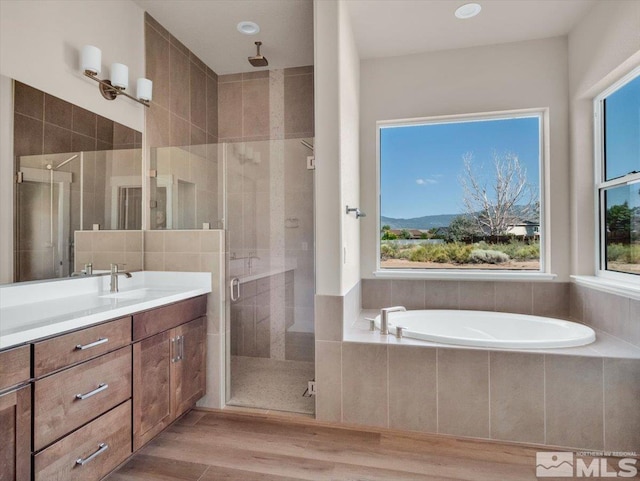 bathroom with shower with separate bathtub, vanity, and hardwood / wood-style flooring