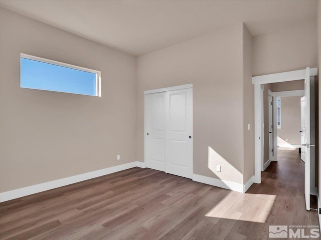 unfurnished bedroom featuring hardwood / wood-style floors and a closet