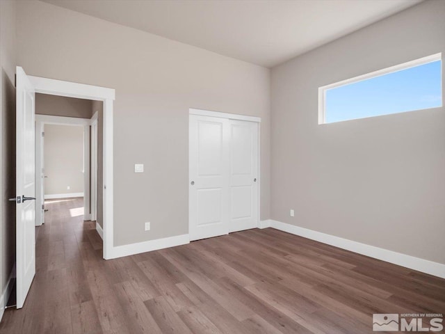 unfurnished bedroom with hardwood / wood-style floors and a closet