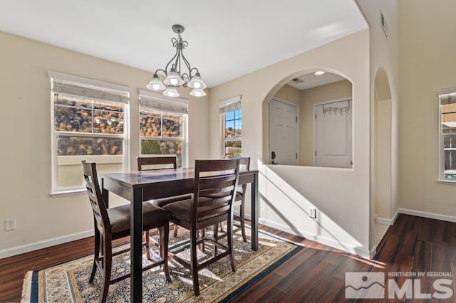 dining area with a chandelier and dark hardwood / wood-style flooring