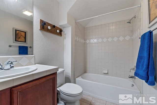 full bathroom featuring tile patterned flooring, vanity, toilet, and tiled shower / bath combo