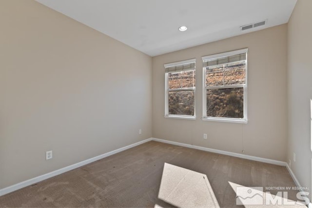 unfurnished room with dark colored carpet