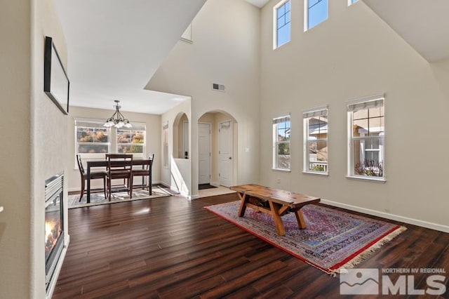 living room featuring a chandelier, a high ceiling, and hardwood / wood-style flooring