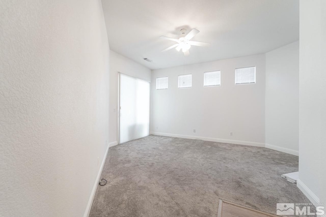 carpeted spare room featuring ceiling fan