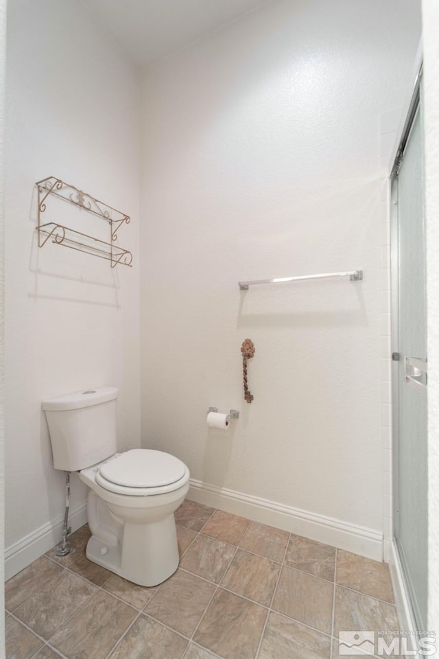 bathroom with toilet and a shower with shower door