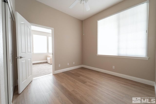 spare room with ceiling fan and light wood-type flooring