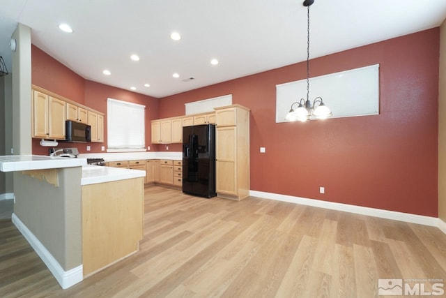 kitchen featuring light brown cabinets, a notable chandelier, kitchen peninsula, light hardwood / wood-style floors, and black appliances