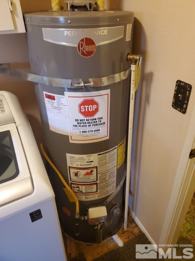 utility room with secured water heater and washer / dryer