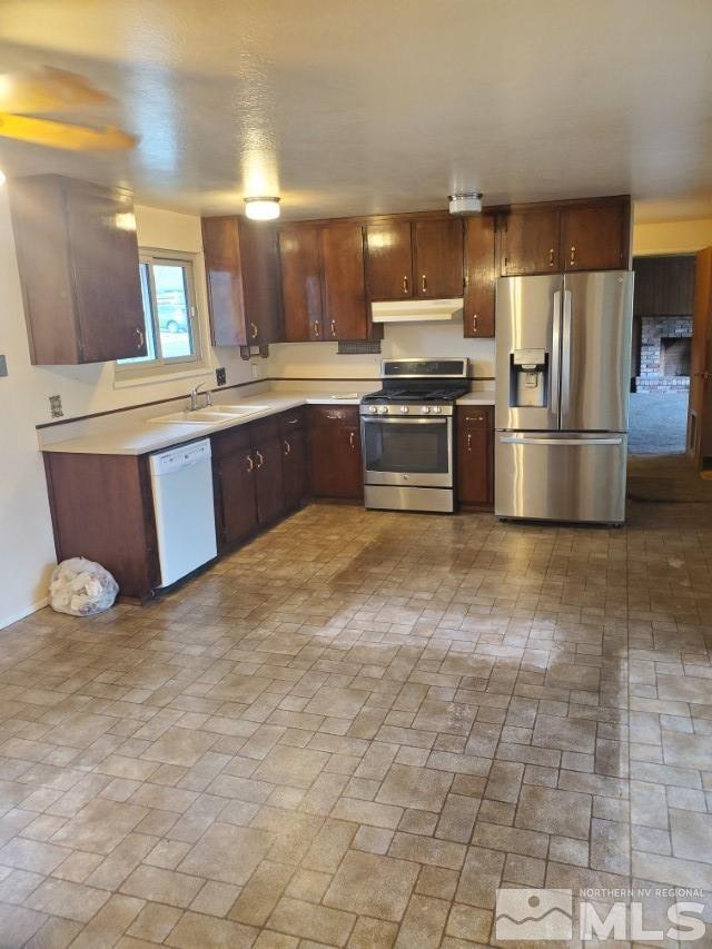 kitchen featuring dark brown cabinets, sink, and appliances with stainless steel finishes