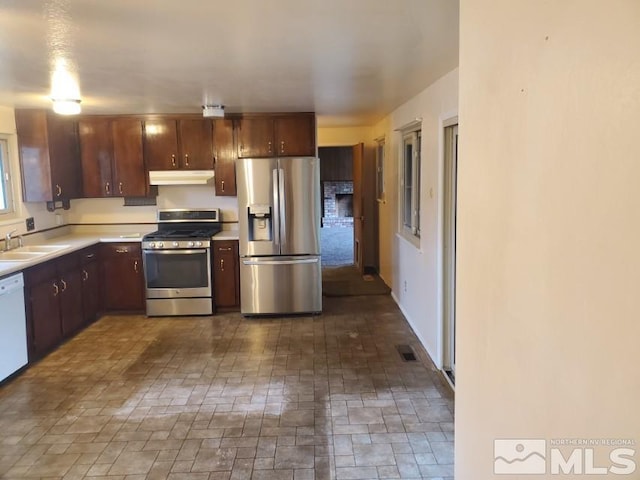 kitchen with dark brown cabinets, stainless steel appliances, and sink