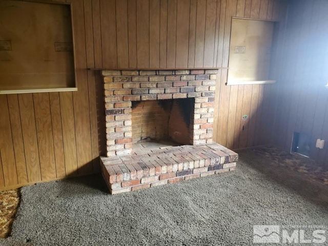 interior details with a fireplace, carpet floors, and wooden walls