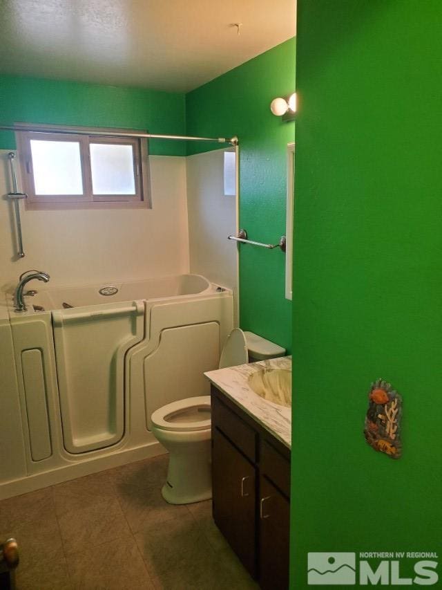 bathroom featuring vanity, toilet, and a bathing tub