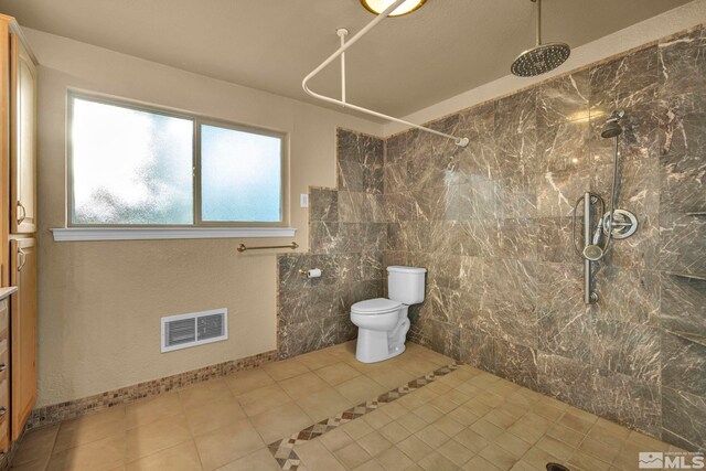 bathroom featuring tile patterned flooring, toilet, and a shower