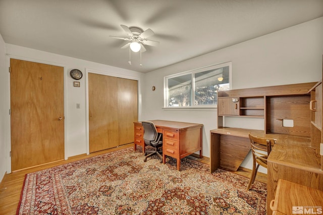 home office with ceiling fan and light hardwood / wood-style flooring