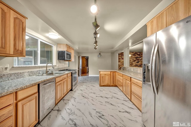 kitchen with light stone counters, sink, stainless steel appliances, and track lighting