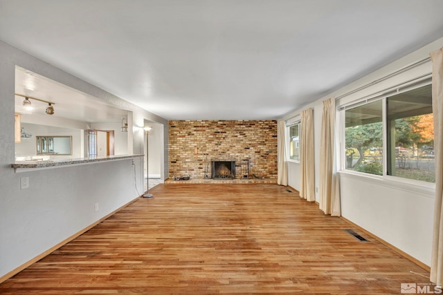 unfurnished living room featuring a fireplace and light hardwood / wood-style flooring