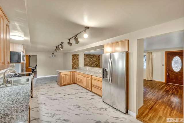 kitchen featuring kitchen peninsula, appliances with stainless steel finishes, light brown cabinetry, sink, and light hardwood / wood-style floors