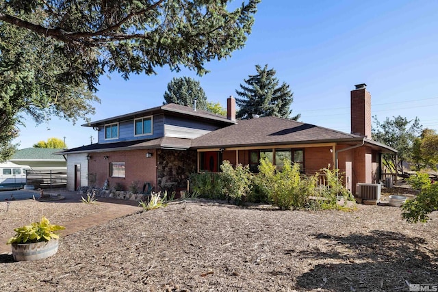 view of front of house with a chimney, fence, and brick siding