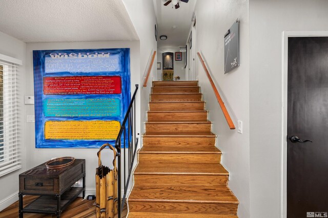 stairs featuring wood-type flooring and a textured ceiling