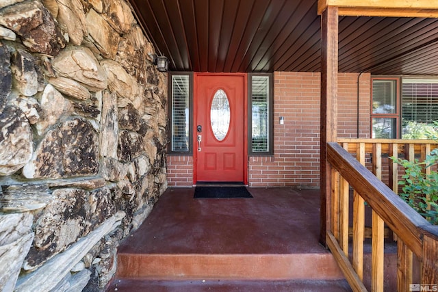 doorway to property featuring brick siding